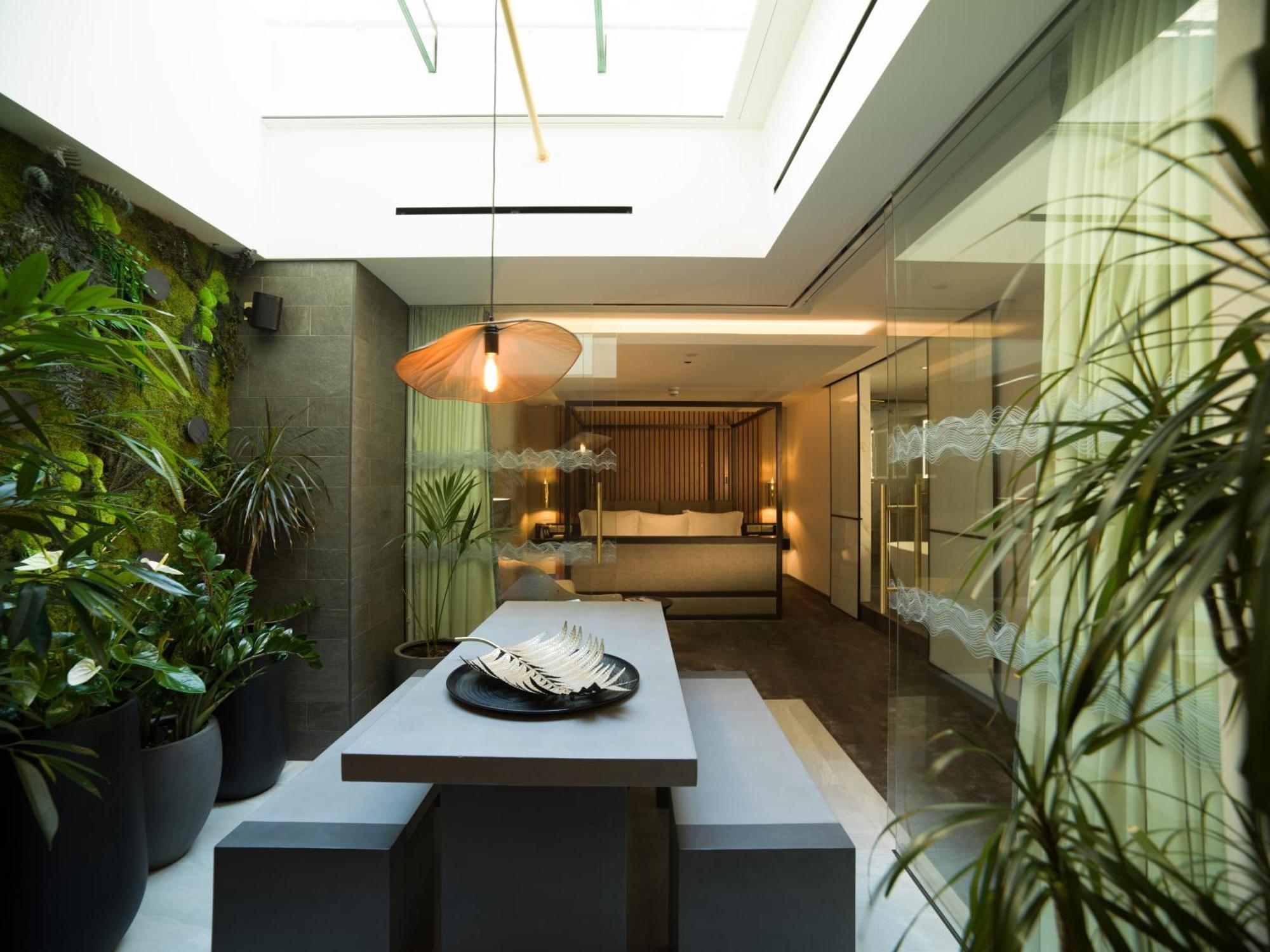 Middle Eight - Covent Garden - Preferred Hotels And Resorts London Luaran gambar The photo depicts a modern, airy interior space that features a dining area. The dining table is rectangular and made of a light-colored material, paired with simple benches on either side. Above the table, there is a stylish pendant light, providing
